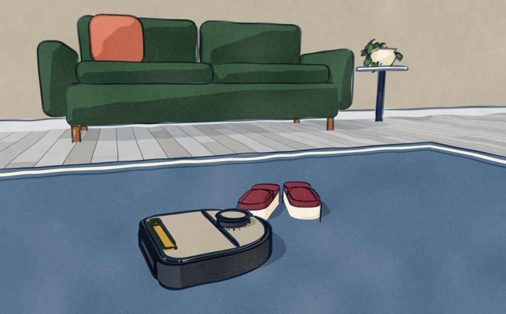 Close over an older Neato robot vacuum out on a living-room rug, set off by its own start button, a pair of slippers left on the rug beside it and a green sofa behind.