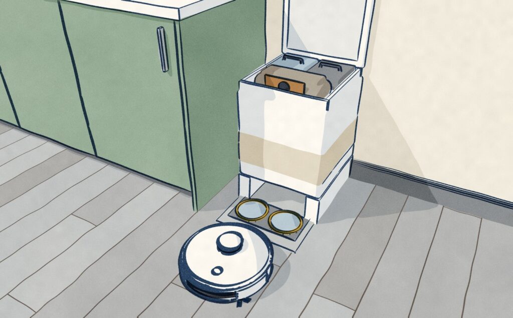 Looking down into a Dreame X50 Ultra's open dock in the same kitchen: the full dust bag sits in front of the clean and dirty water tanks, and the white robot rolls off its two gold-rimmed wash wells.
